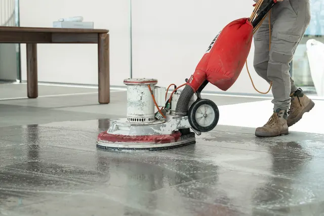 Machine scrubbing a stone floor after construction
