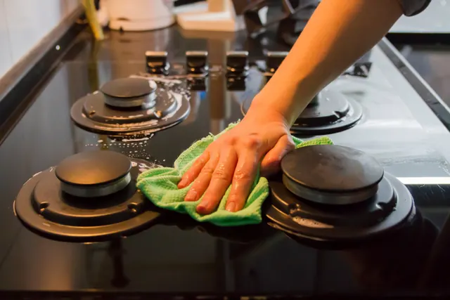 Degreasing a gas stovetop with a microfiber cloth